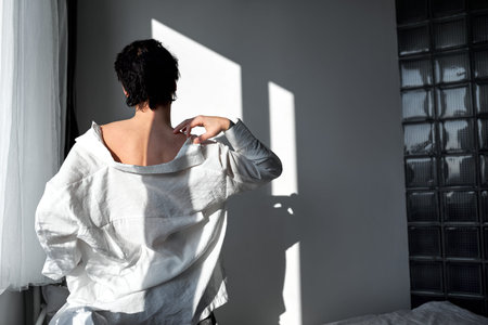 sexy young glamour man in stylish white shirt scratching his neck, shoulder, back view shot. copy...