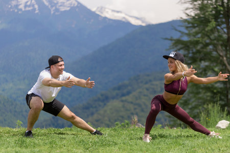 fitness, sport, people, exercising and lifestyle concept - couple doing join workout squats on city street stairsの写真素材