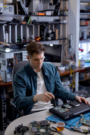 Repairs and diagnostics breakdowns of laptop in professional service center. Professional electronic master in workshop, using different tools or instruments. computer repair conceptの写真素材