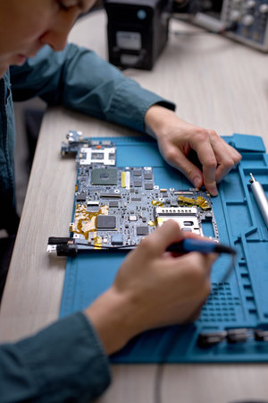 top view on technician or Engineer installing CPU microprocessor to motherboard socket on workplace...