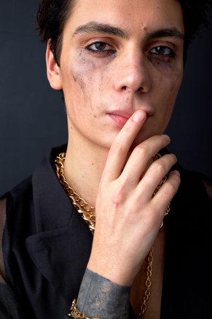 young caucasian upset gay posing with mascara smudged from crying because of discrimination. Concept...