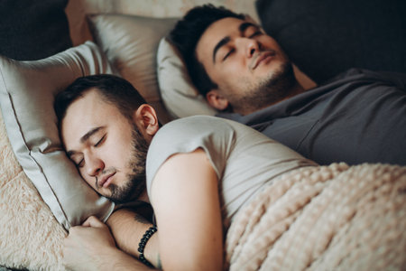 Positive delighted non-traditional couple sleeping together, happy alternative family concept.の写真素材