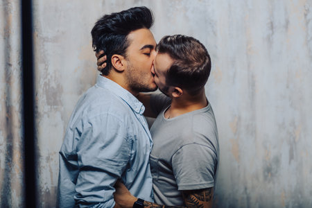 Sensual Gay Males giving deep kiss, embracing, feeling passion and love, posing isolated over grey studio wallの写真素材