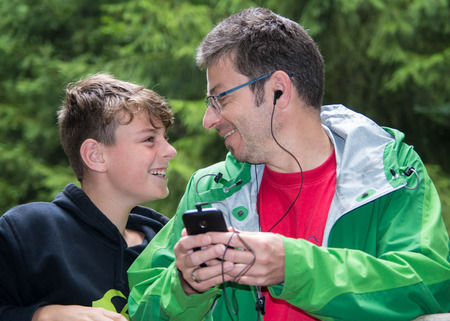 father with son are listening to musicの写真素材