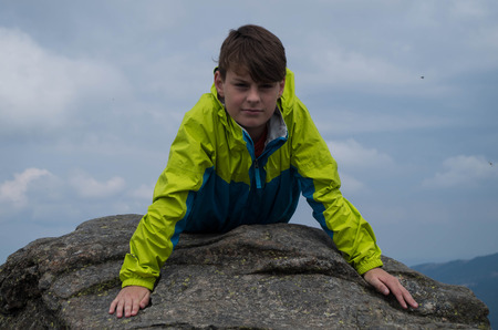 Young while relaxing on the mountain topの写真素材