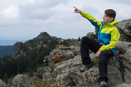 Young while relaxing on the mountain topの写真素材