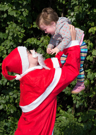 Santa Claus with toddler in summerの写真素材