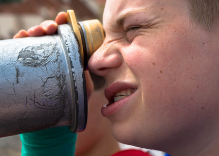 Young man with telescopeの写真素材