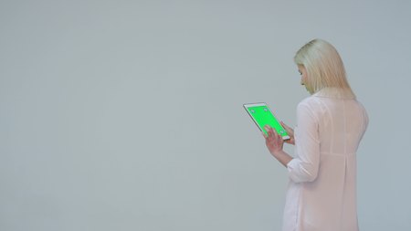 Doctor pressing the green screen of a tablet computer against white backgroundの写真素材