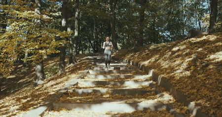 Runner woman getting ready to run and starts running in wearing earphones listening to musicの写真素材