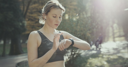 Fitness Woman In Wireless Earphones Using Smartwatchの写真素材