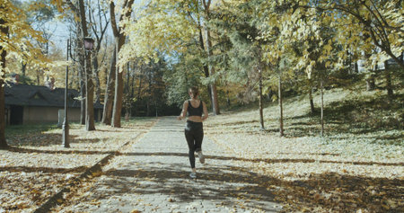 Young active female athlete exercising outdoor in the sunny autumn
