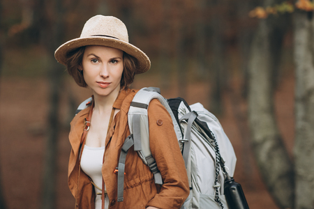Portrait woman traveler with backpack looking at amazing forestの写真素材