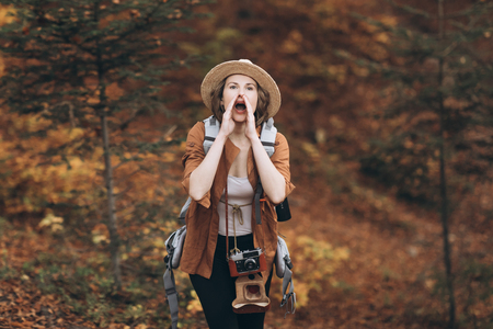 Look, pretty cool young woman model with retro film camera wearing a elegant hatの写真素材