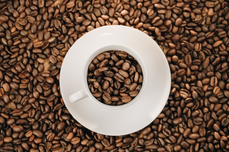 Coffee cup with roasted coffee beans on wooden backgroundの写真素材