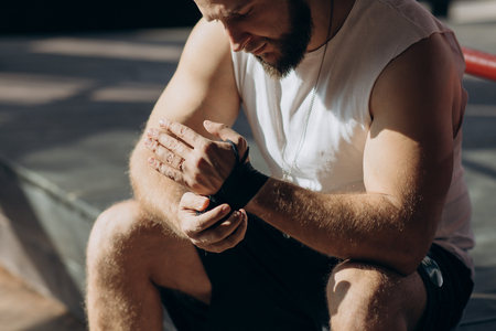 Male boxer wraps his hands with black handwrap before the fight trainingの写真素材