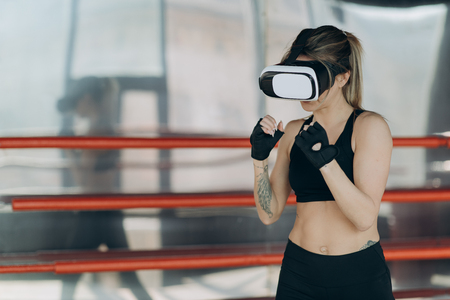 Attractive woman boxing in VR 360 headset training for kicking in virtual realityの写真素材