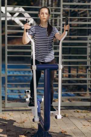 Woman doing fitness training at the outdoor gym in park. Athletic and fitness training outdoors....
