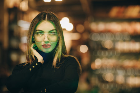 Model looking through window. Lady wearing eyeglasses, wrist watch. Indoor close up portrait of...