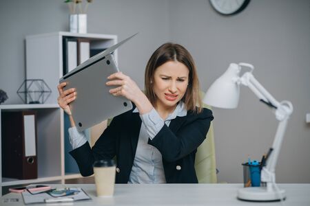 Business woman reading bad news on laptop computer at coworking space. Upset woman closing down laptop in office. Tired woman breathing deep at workplace. Business woman doing yoga exercise.の写真素材