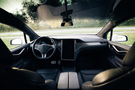 Electric car interior details of door handle with windows controls and adjustments. Inside car...
