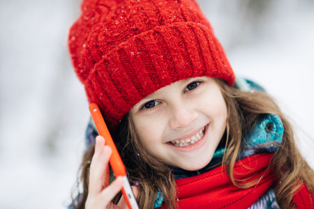 Close up of young beautiful woman in winter hat talking emotionally and surprised talking on cell...