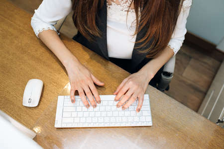 Business womans hands typing on keyboard. Closeup of womans hands touching keys trying to access data during workの写真素材