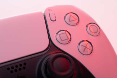 Lviv, Ukraine - February 27 2021: Close up parts of joystick from new Sony PlayStation 5 set-top box. White controller from TV game box in red lightのeditorial素材