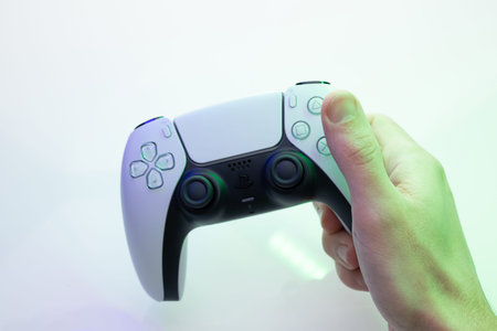 Lviv, Ukraine - 27 February 2021: Player is holding controller of new PlayStation 5 game console....