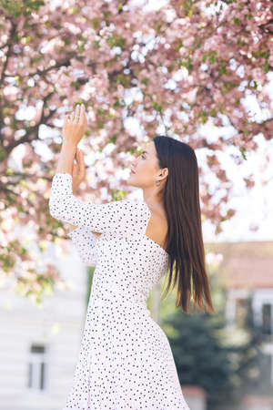 Girl with pink cherry blossom petals in cherry blossom forest.の写真素材