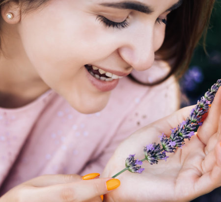 Portrait of beautiful romantic woman in fairy field of lavender with bouquet. Woman on lavender field portrait. Young woman in dress outdoorsの写真素材