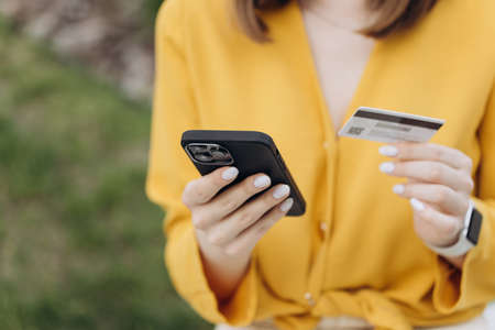 Female Hands holding credit card and using smartphone. Online shopping.の写真素材