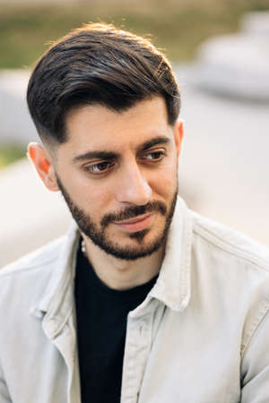 Portrait of young caucasian bearded man opening his eyes. Male beautiful brown eyes looking at camera. Confident guy with attractive and deep sightの写真素材