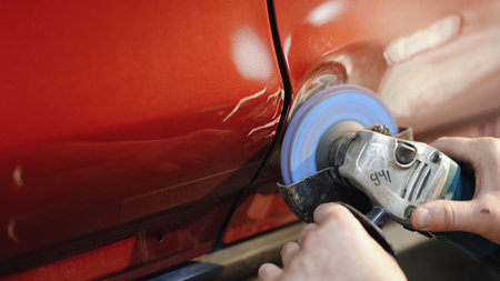 Car body panel repairing on the garage, car door panel dent removing. Auto repairman grinding...