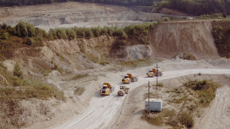 Heavy Dump Trucks At The Coal Mining Area. Aerial view of the quarry mining trucks, heavy industry...