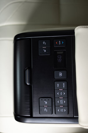 Control unit with electric seat adjustment media system for rear passengers in car. Element of interior car armrest with electric seat adjustment and media. Car leather seats for rear passengersの写真素材