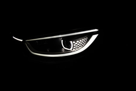 Switched on led matrix lights of luxury car. Car front full led matrix IQ Light. Modern car headlamp flashing light with blinking on continuously indicator. Car Blinker Light.の写真素材