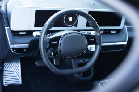Black leather dashboard, climate control, speedometer, display, wood decoration. Car steering wheel....
