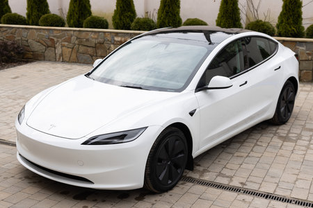 Lviv, Ukraine - March 23, 2024: White Tesla Model 3 highland electric car in showroom, trends in use EV in contemporary Europe, latest technologies in automotive industry, environmentally sustainableのeditorial素材