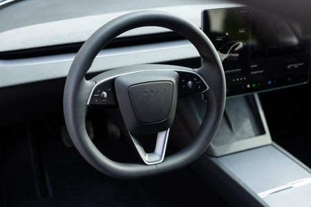 Lviv, Ukraine - March 23, 2024: Tesla Model 3 highland electric car steering wheel. Leather dashboard, climate control, speedometer, display, decoration. Expensive car interior with steering wheelのeditorial素材