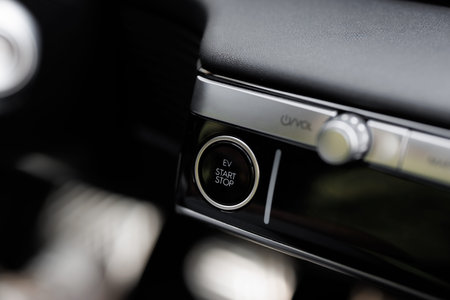Pushing start stop Button to start keyless ignition hybrid car electro engine. Starting car engine....