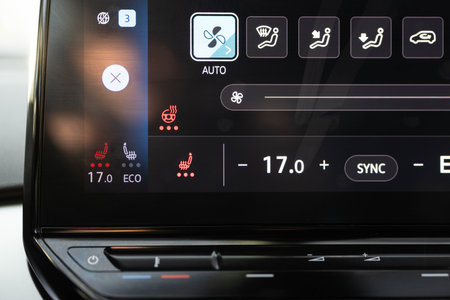 Heated seat dashboard in a car. Steering wheel heating button in the car. Switching ON heated seats of car by pressing the buttons. Electric car control panel with steering wheel and seat heatingの写真素材