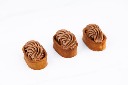 Caramel tartlet, caramelized peanuts, salted caramel, chocolate ganache. Dessert of dough, nut tartlets covered with a layer of caramel. Tartlet with caramelized nuts isolated on white. Tasty dessertの写真素材