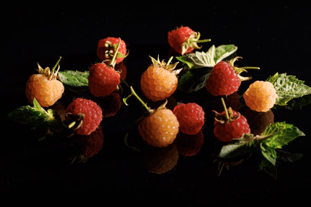 Fresh red ripe raspberries. Sweet ripe fresh delicious raspberry, summer berry, organic food, vitamins. Raspberry with leaves. Raspberry isolated on black backgroundの写真素材