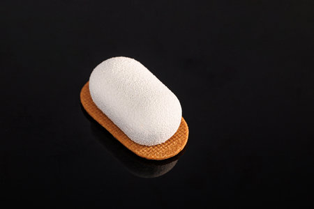 Creme brulee mousse cake. Vanilla sable, chocolate sponge, coffee baileys icing. Creme brulee cake with vanilla sable and chocolate sponge on a black background. Space for text or designの写真素材