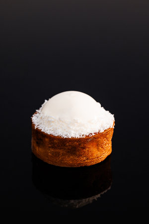 Coconut tartlet with gluten-free sponge cake, pineapple kulie, coconut mousse, icing. Tartlet with coconut cream and pineapple kulie. Tasty sweet dessertの写真素材