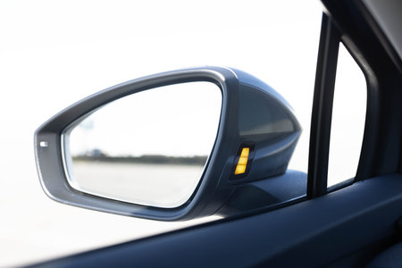 System blind spots of the car. Detail of side keeping assist system switch button. Blind zone monitoring sensor on the side mirror of a modern electric carの写真素材