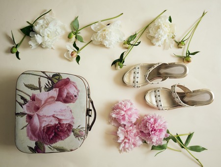 peonies with buds, sandals and womens handbags on the table. top viewの写真素材