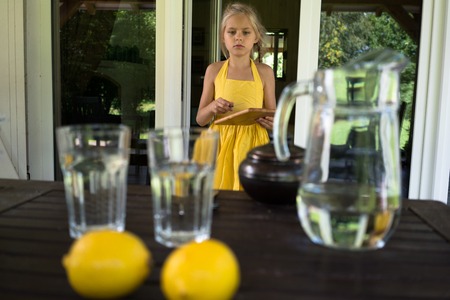 lemons and glass jug with glasses in the summer on a background of a windowの写真素材
