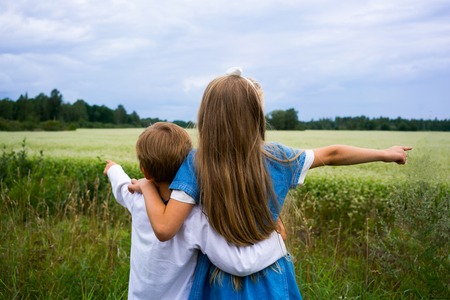 boy and girl on the background of summer fieldの写真素材